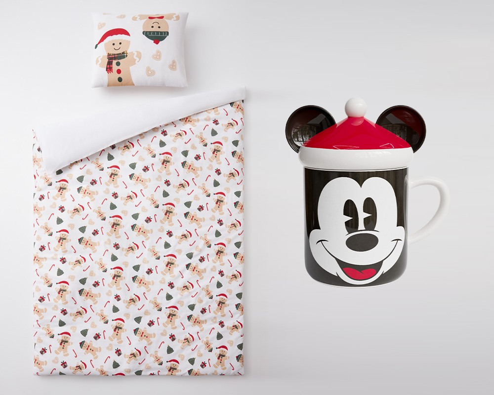 Ropa de cama navideña de Pepco para un regalo infantil junto a una taza de regalo de Navidad con motivos de Mickey Mouse.