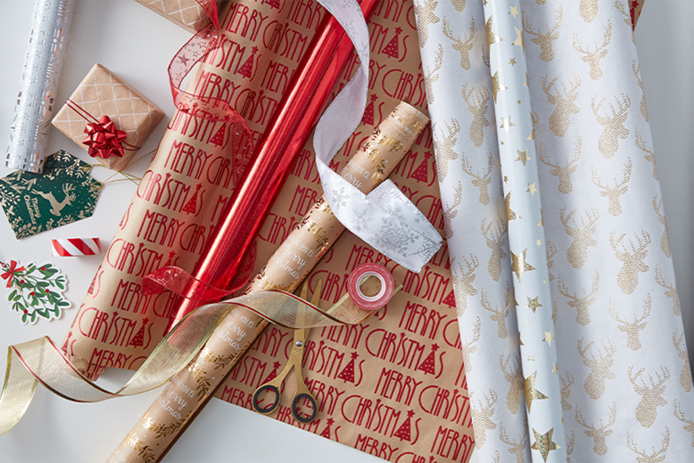 Papel de regalo navideño, cintas y accesorios de embalaje.